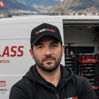 Marc, fondateur de Mob'Glass, casquette Mob'Glass devant le camion-atelier